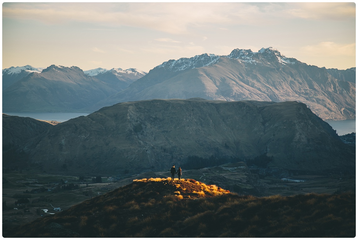 Couple stand on mountain top in Queenstown