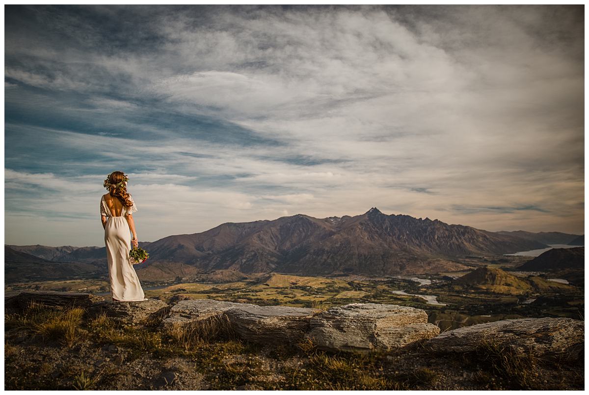 Queenstown boho bride looks out at the mountains from Coronet Peak