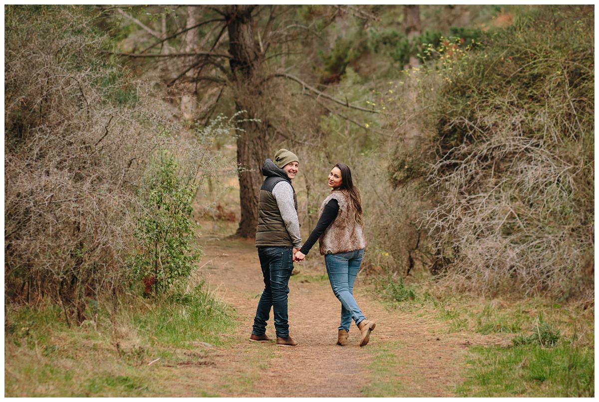 Couple walk through the forest at Queenstown engagement