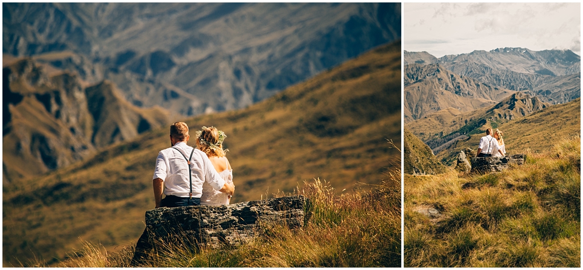 Bride and groom sit on a rock looking out over the mountains