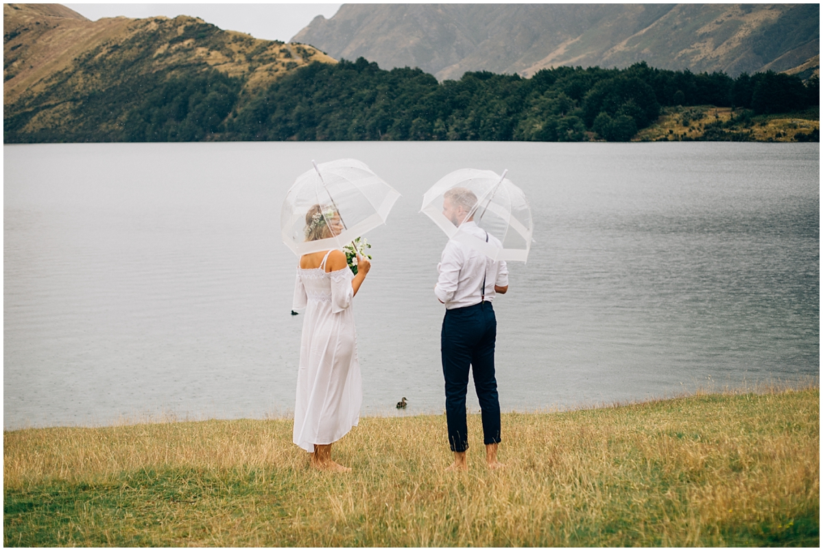 Bride and groom look out over Moke Lake and the mountains