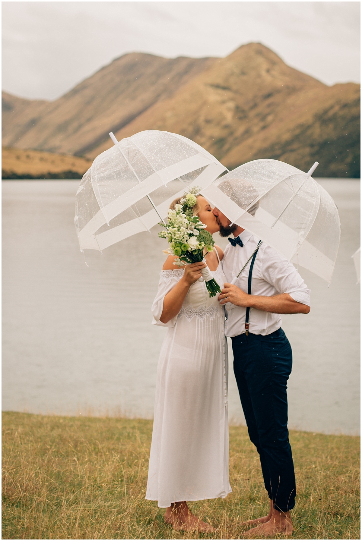 Couple kiss under umbrellas at Queenstown elopement