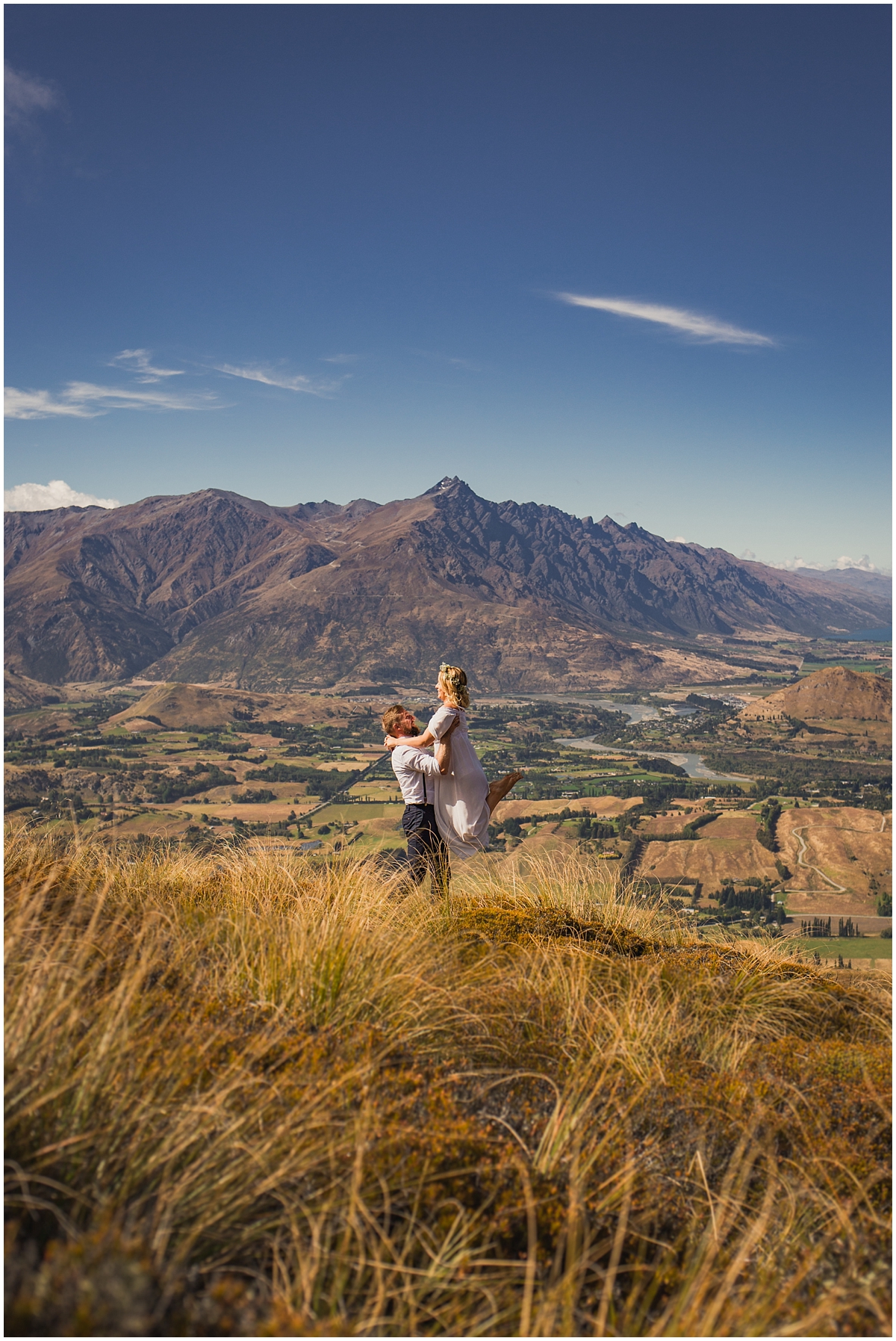 Bride jumps into groom's arms on a hillside