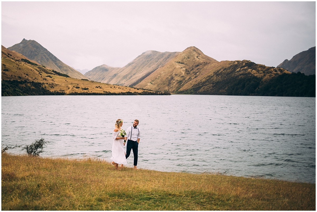 Bride and groom walk along Moke Lake's edge at Queenstown elopement