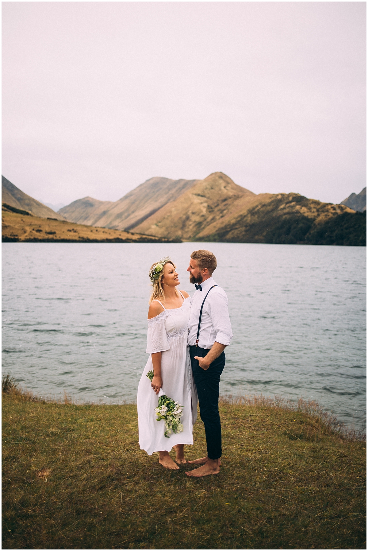 Bride and groom stand at Moke lake's edge