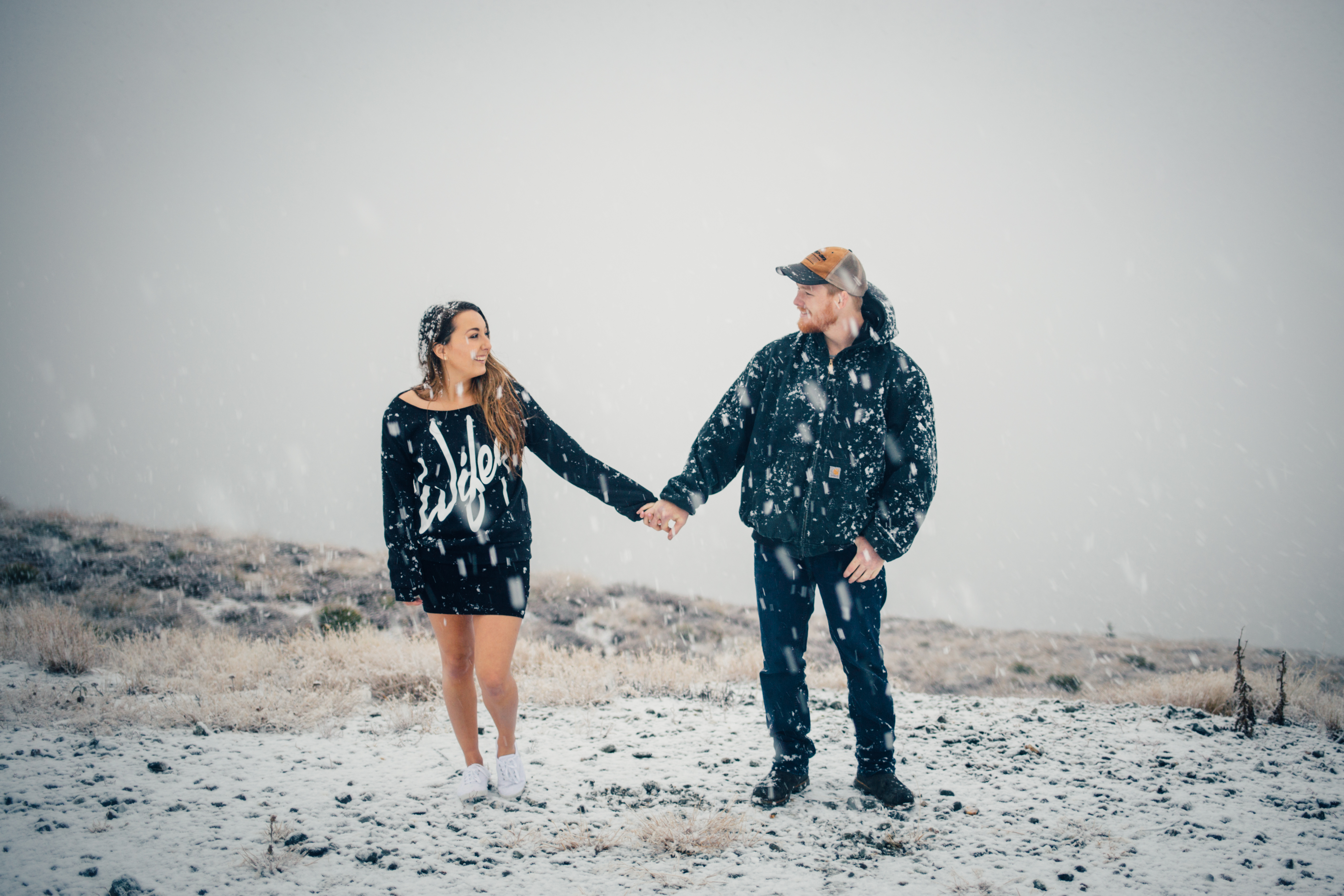 young couple holding hands in the snow