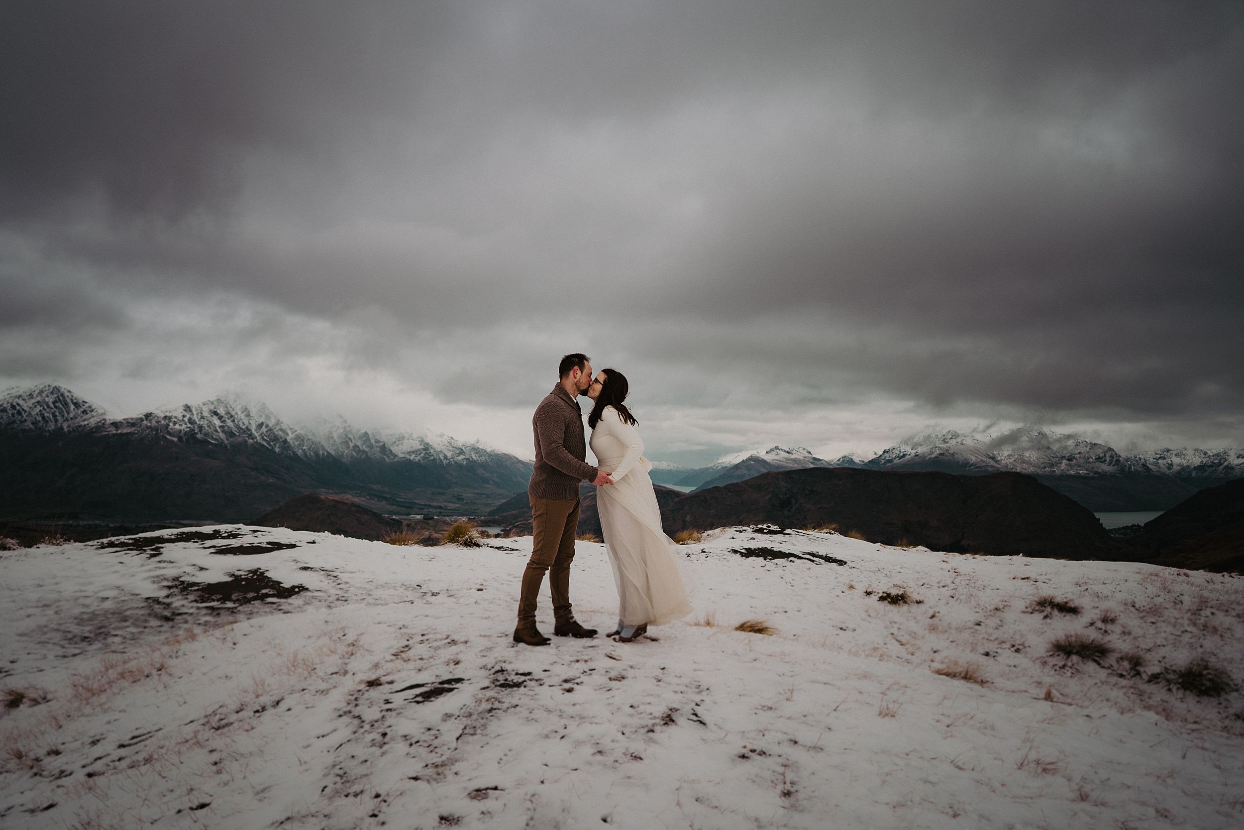 couple kissing on snow covered mountain